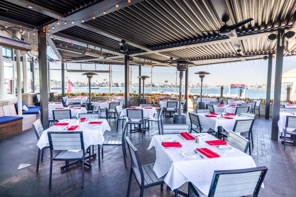 Patio seating and waterfront views at Boathouse on the Bay