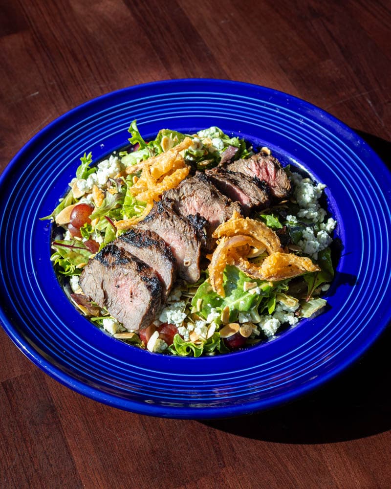 Skirt Steak Salad with blue cheese, grapes, and almonds at Boathouse on the Bay, from the original Mum's menu and returning at its 2004 price